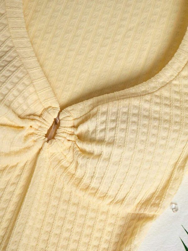 Sunnyshic T-shirt à manches courtes col V avec bouton décoré au centre, en tissu texturé jaune. Extrêmement doux et confortable. Conception minimaliste polyvalente pour les vacances et le quotidien pour les femmes. Été. – Image 6