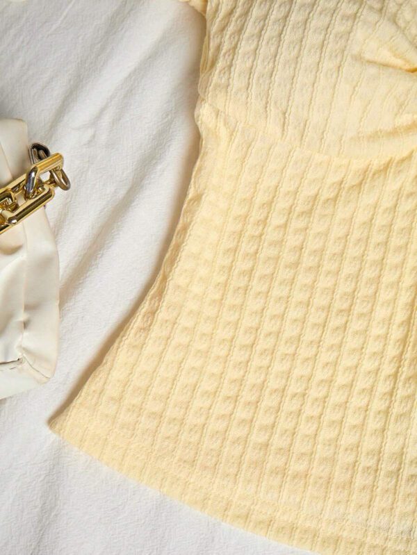 Sunnyshic T-shirt à manches courtes col V avec bouton décoré au centre, en tissu texturé jaune. Extrêmement doux et confortable. Conception minimaliste polyvalente pour les vacances et le quotidien pour les femmes. Été. – Image 7